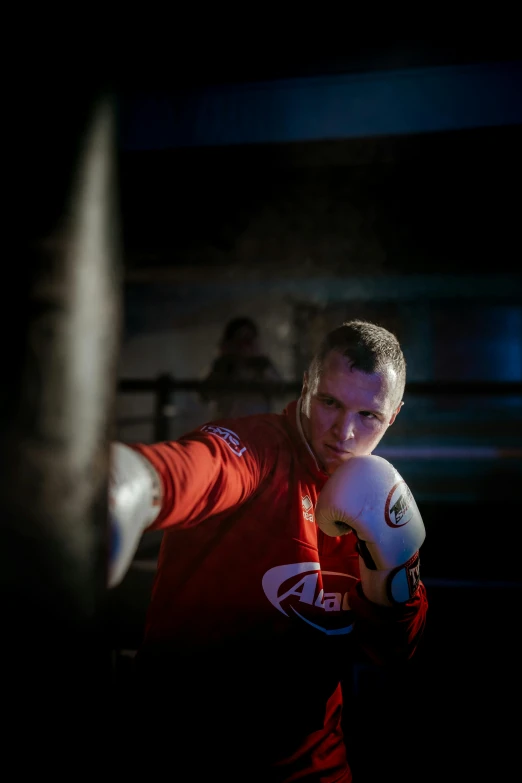 a man standing next to a punching bag, a portrait, by Julian Allen, pexels contest winner, ringflash, sparring, ray swanland, profile image