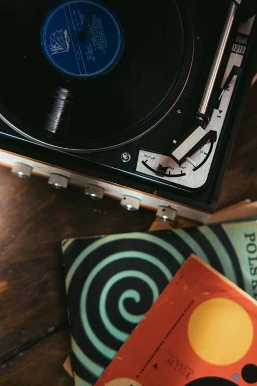 a record player sitting on top of a wooden table, an album cover, trending on pexels, kinetic art, close-up from above, 1960s color photograph, dj set, ilustration