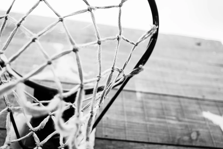 a black and white photo of a basketball hoop, a picture, net art, brine lacrosse stick, high details photo