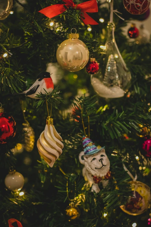 a close up of a christmas tree with ornaments, birds and trees, looking towards the camera, zoomed in, cosy