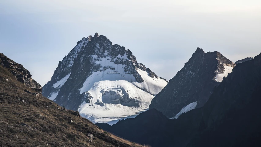 a group of people walking up the side of a mountain, by Werner Andermatt, pexels contest winner, hurufiyya, seen from a distance, devil's horns, with snow on its peak, high details photo