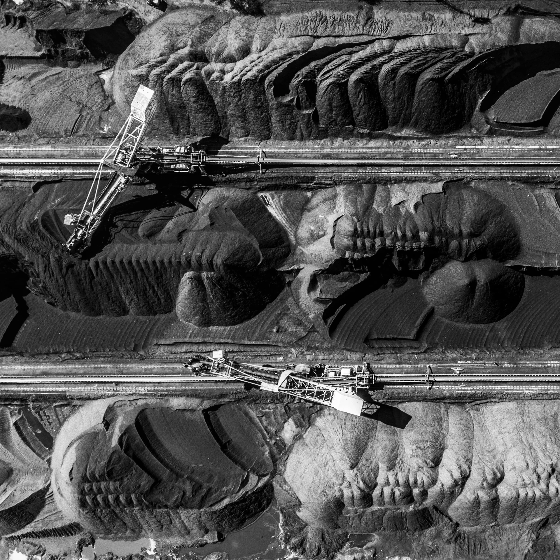 a black and white photo of a conveyor belt conveyor belt conveyor belt conveyor belt conveyor belt conveyor belt conveyor belt, by Werner Gutzeit, birds eye photograph, erosion, award winning image, flowing lava and ash piles