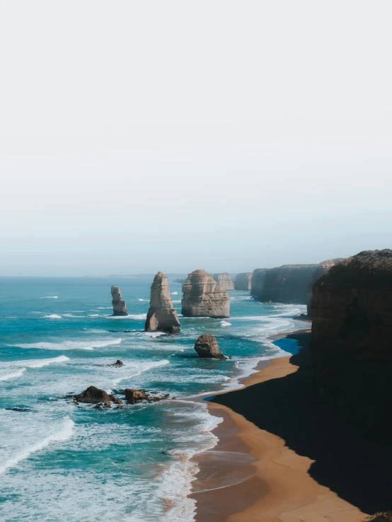 a large body of water next to a sandy beach, pexels contest winner, monoliths, australian beach, coastal cliffs, high quality image”