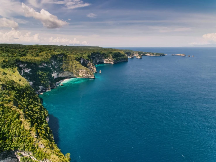 a large body of water next to a lush green hillside, a cartoon, pexels contest winner, sumatraism, ocean cliff view, blue ocean, conde nast traveler photo, archipelago