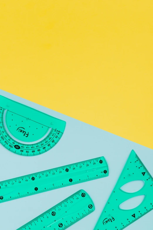 a group of rulers sitting on top of a table, trending on pexels, academic art, cyan and green, graphic shapes, product introduction photo, teal