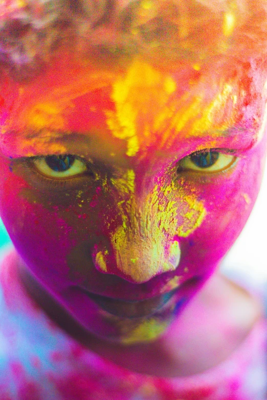 a close up of a person with paint on their face, inspired by Steve McCurry, pexels contest winner, color field, radiant vibrant colors, glowing pink face, hinduism, glowing yellow face