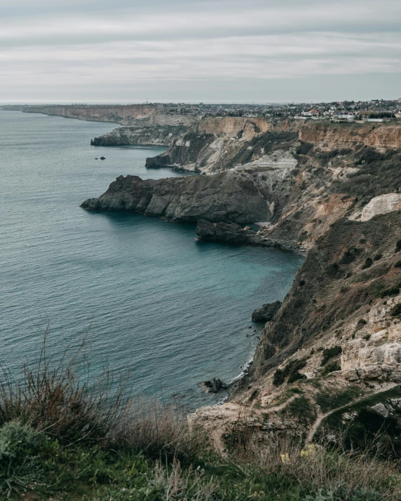 a man standing on top of a cliff next to the ocean, coastal cliffs, non-binary, trending photo, portugal