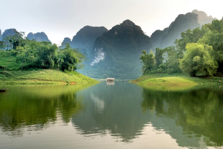 a body of water with mountains in the background, a picture, bao phan, waterway, conde nast traveler photo