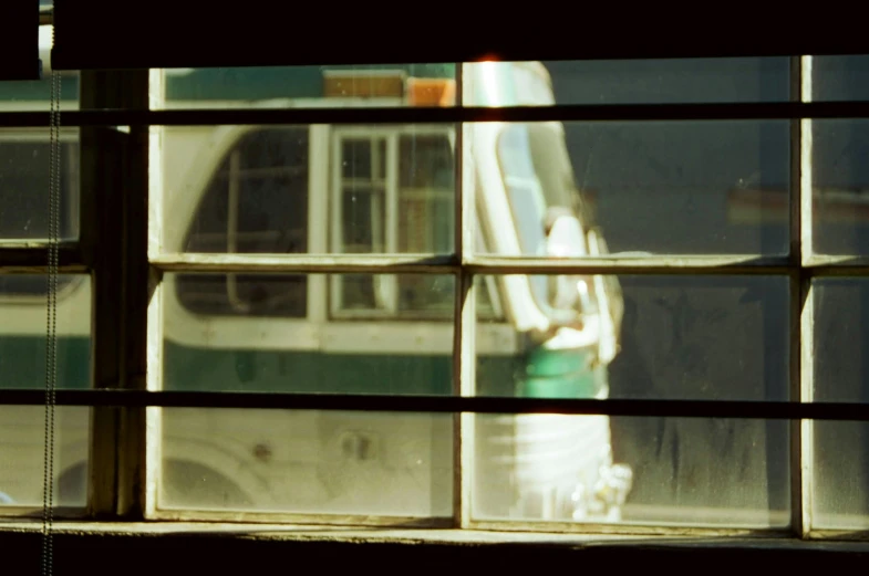 a fire hydrant is seen through a window, inspired by Vivian Maier, buses, 3 5 mm slide, large green glass windows, 1999 photograph