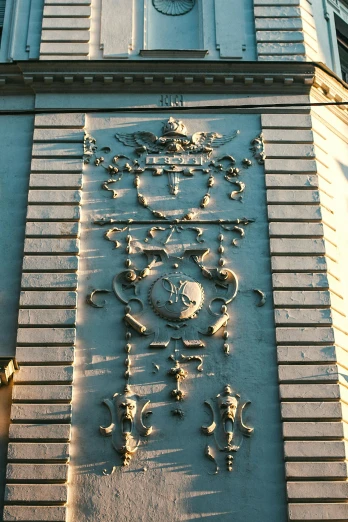 a clock that is on the side of a building, inspired by Édouard Detaille, art nouveau, ornate iron armour, evening sun, etched relief, on a large marble wall