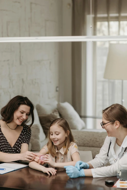 a group of people sitting around a table, with a kid, with a stethoscope, high-quality photo, at home