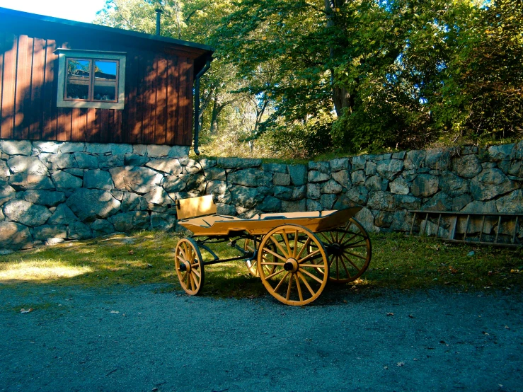 a wooden wagon sitting in front of a stone wall, by Harry Haenigsen, unsplash, swedish countryside, color picture, riding, minna sundberg