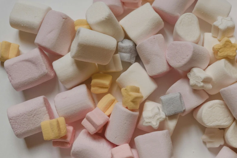 a pile of marshmallows on a white surface, inspired by Sarah Lucas, pexels contest winner, vintage shapes, pastel faded grey rainbow, yellow, various styles