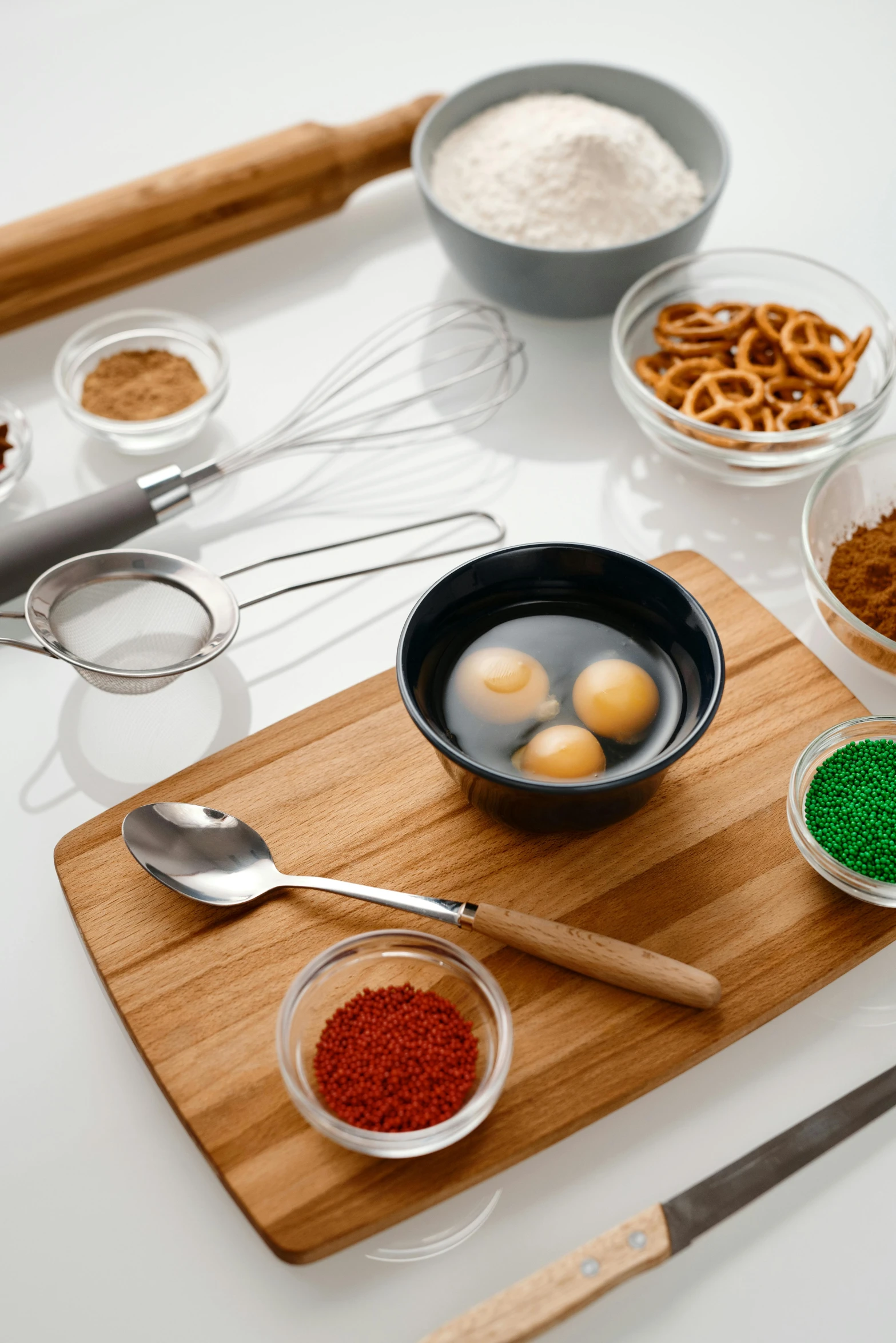 a wooden cutting board topped with bowls of food, eggs, detailed product image, detail shot, cooking