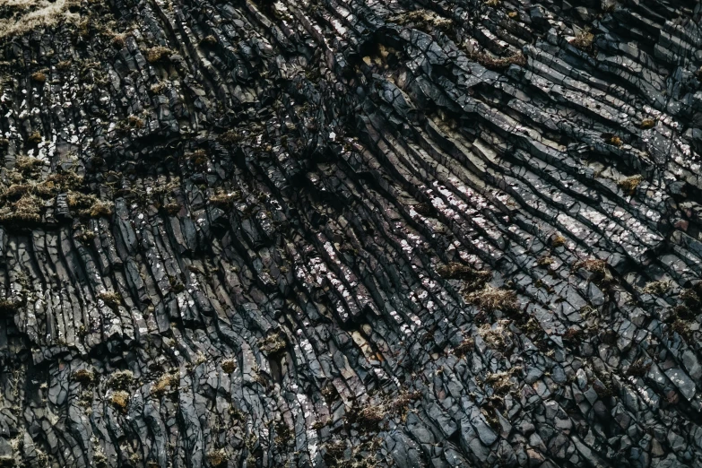 a close up view of a rock formation, an album cover, by Jörg Immendorff, unsplash, auto-destructive art, smouldering charred timber, aerial photography, seamless texture, black slime