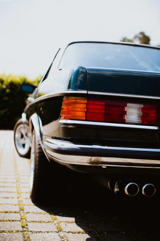 a black car parked on the side of the road, pexels contest winner, renaissance, de tomaso, rear-shot, taken in the late 1980s, profile image