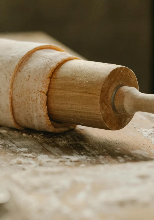 a rolling pin sitting on top of a wooden table, detailed product image, paul barson, pastry, lathe