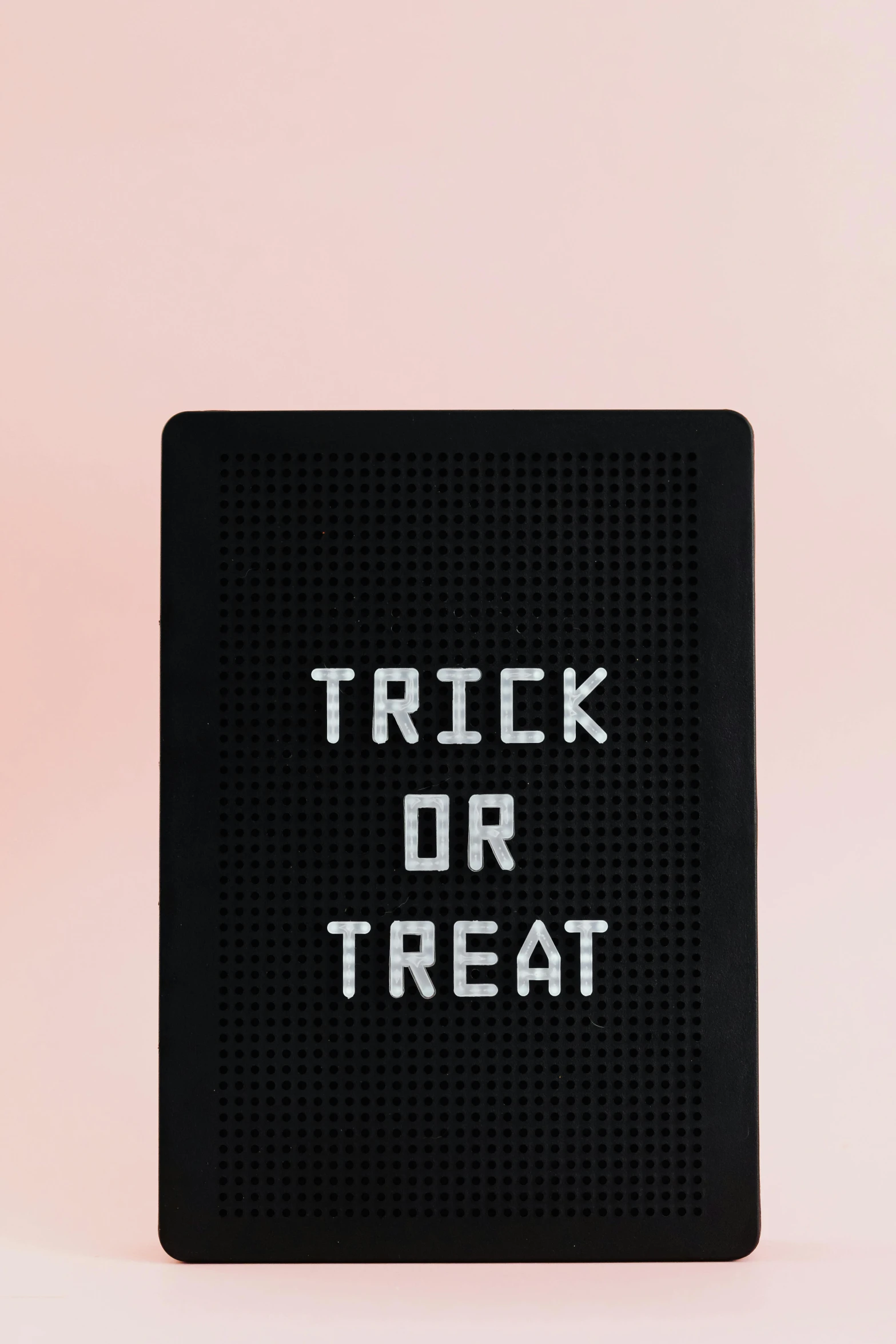 a black board with a trick or treat written on it, by Paul Bird, trending on unsplash, ascii art, electrical case display, on a pale background, close up front view, adafruit