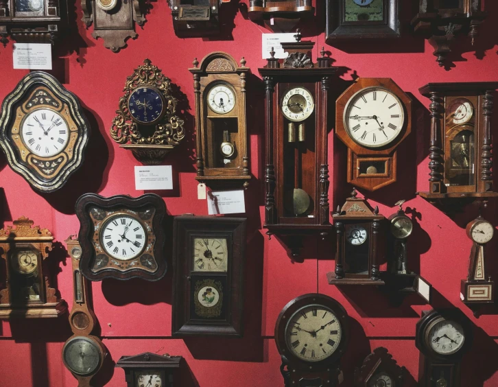 a wall filled with lots of different types of clocks, unsplash, red wall, museum curator, brown, instagram post