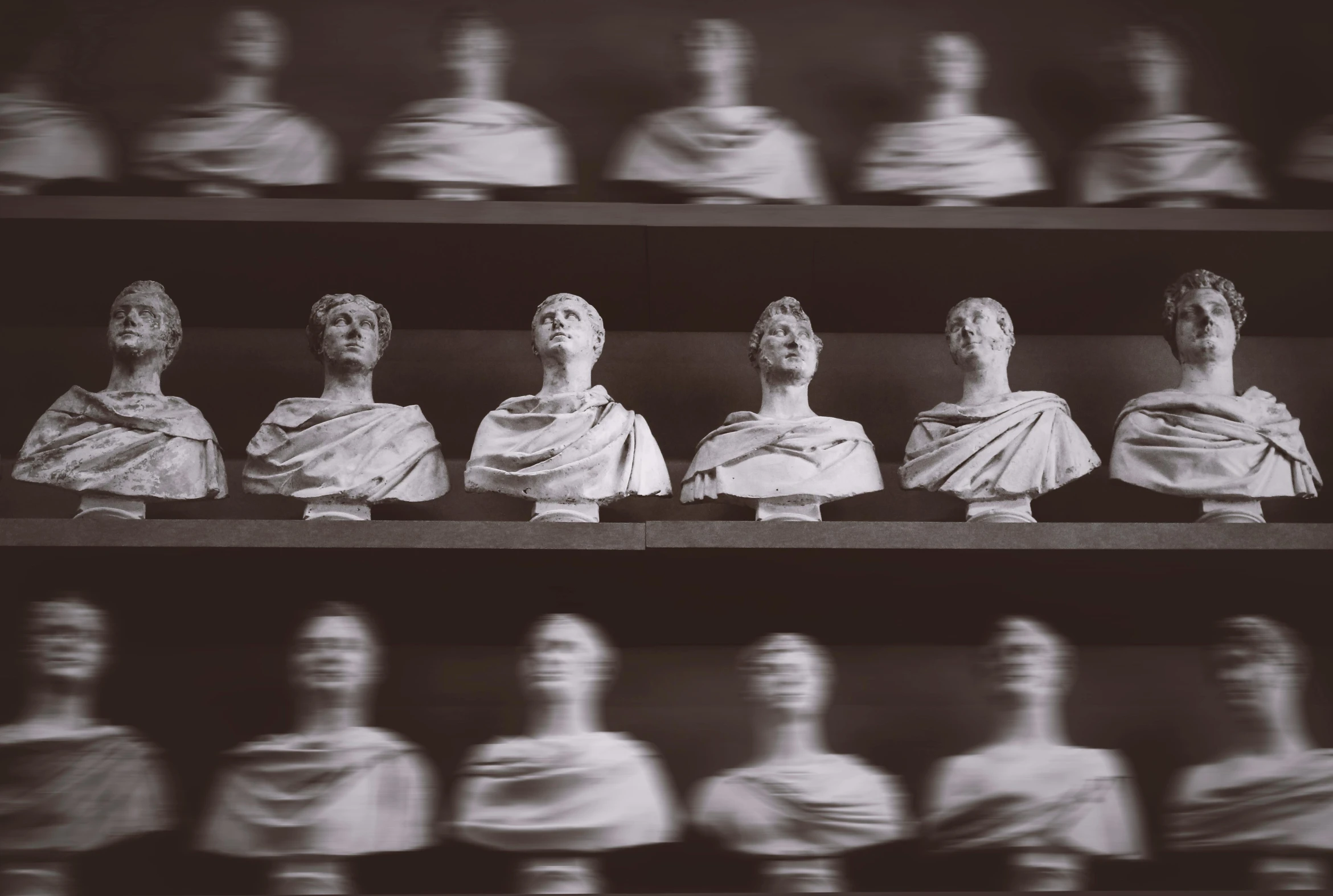 a black and white photo of a bunch of busts, inspired by Pietro Testa, pexels contest winner, neon roman, dusty library, miniatures, repetition