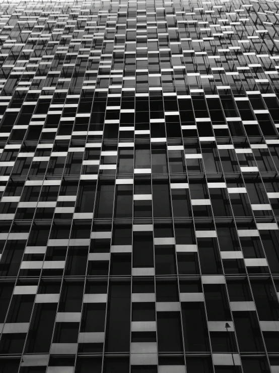a black and white photo of a tall building, a mosaic, inspired by Andreas Gursky, unsplash, square shapes, full of glass. cgsociety, glass texture, stacked