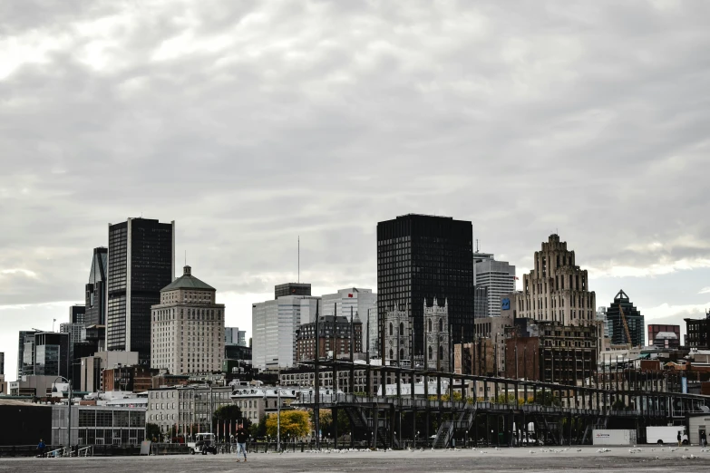 a red fire hydrant sitting in the middle of a parking lot, inspired by Clément Serveau, pexels contest winner, city skyline on background, all buildings on bridge, grey sky, montreal