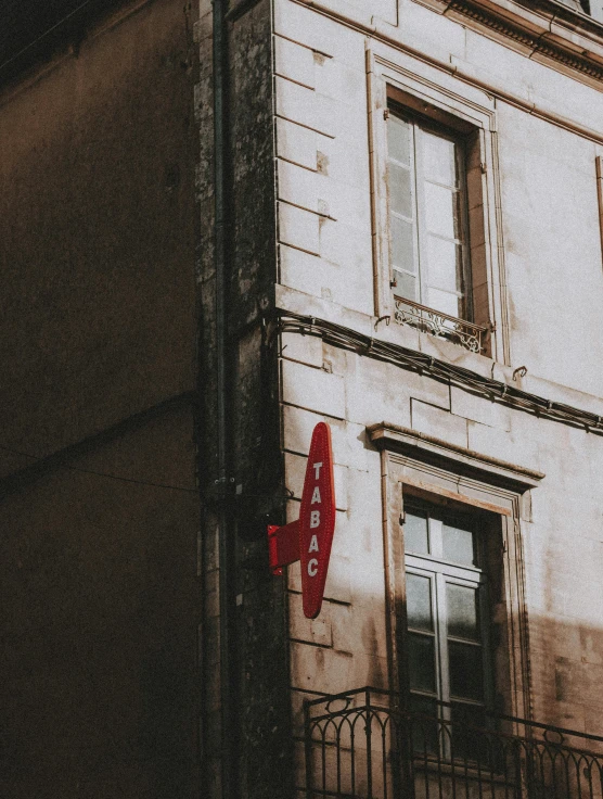 a red sign that is on the side of a building, a photo, pexels contest winner, traveling in france, light academia aesthetic, promo image, the place is just really small