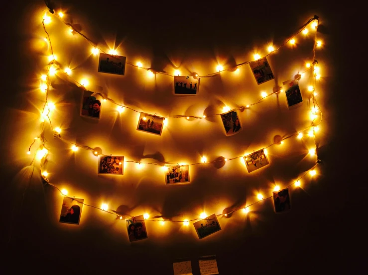 a close up of a string of lights on a wall, a polaroid photo, pexels, visual art, shades of gold display naturally, ambient lighting!, 3 light sources, festive atmosphere