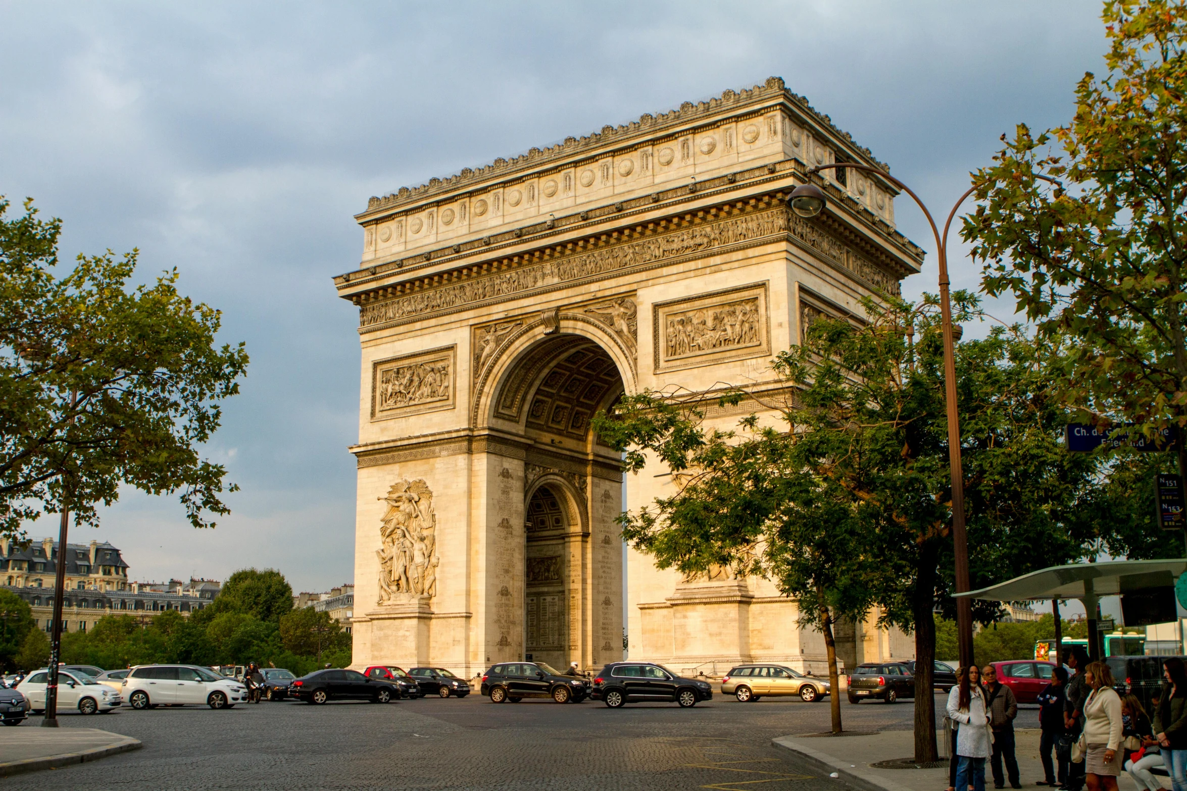 a group of people standing on the side of a road, pexels contest winner, neoclassicism, arc de triomphe full of graffiti, square, brown, slide show