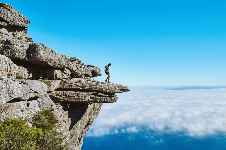 a person standing on a cliff above the clouds, pexels contest winner, south african coast, avatar image, platforms, falling off a cliff