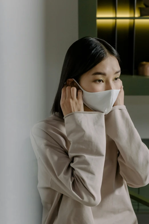 a woman wearing a face mask in a kitchen, inspired by Yu Zhiding, quiet beauty, premium, on grey background, comforting