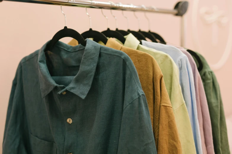 a row of shirts hanging on a rail, by Carey Morris, trending on unsplash, renaissance, some yellow green and blue, cropped shirt with jacket, deep pastel colours, linen