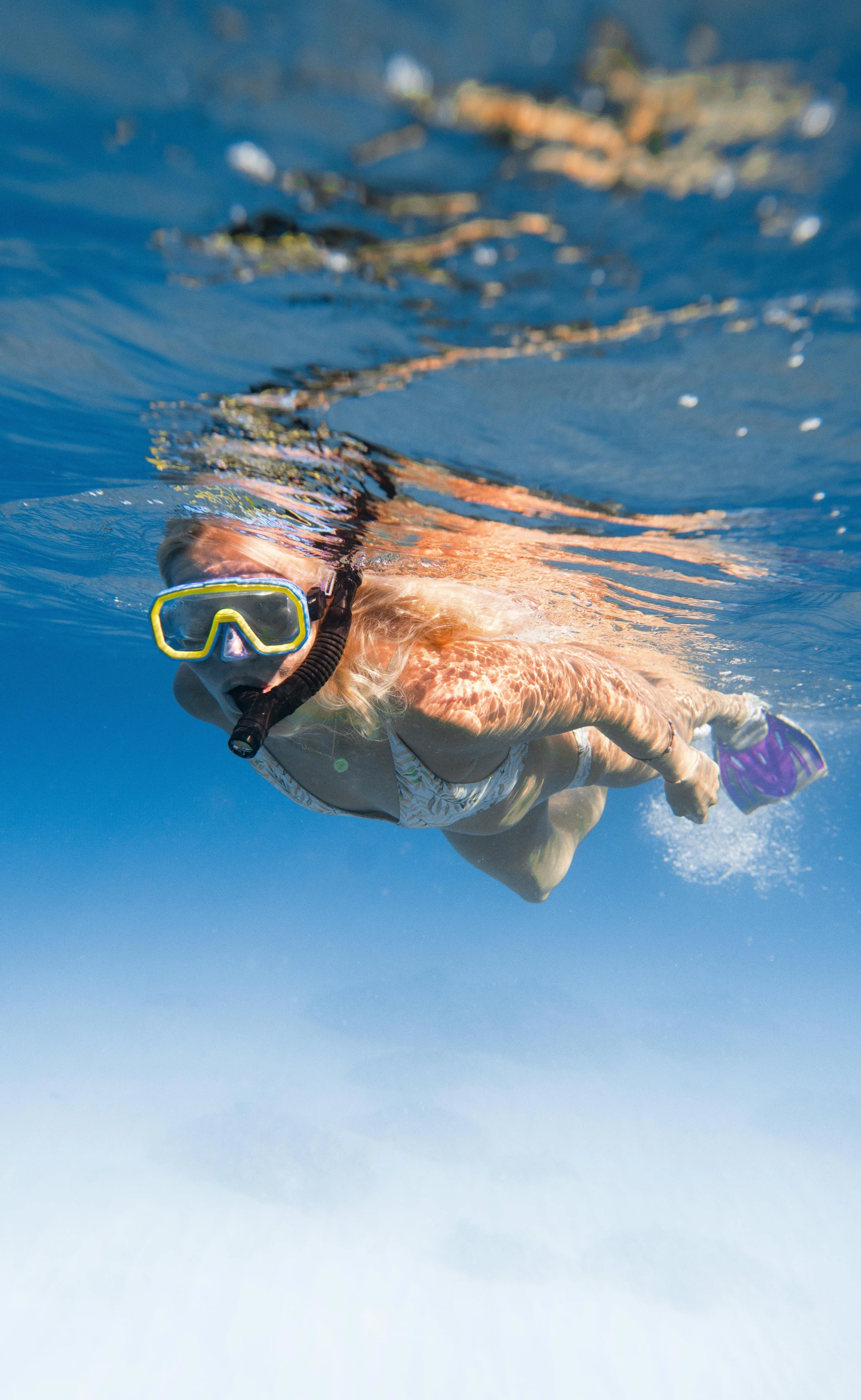 a person swimming in the ocean with a snorg, snout under visor, female ascending into the sky, vivid colours, explore