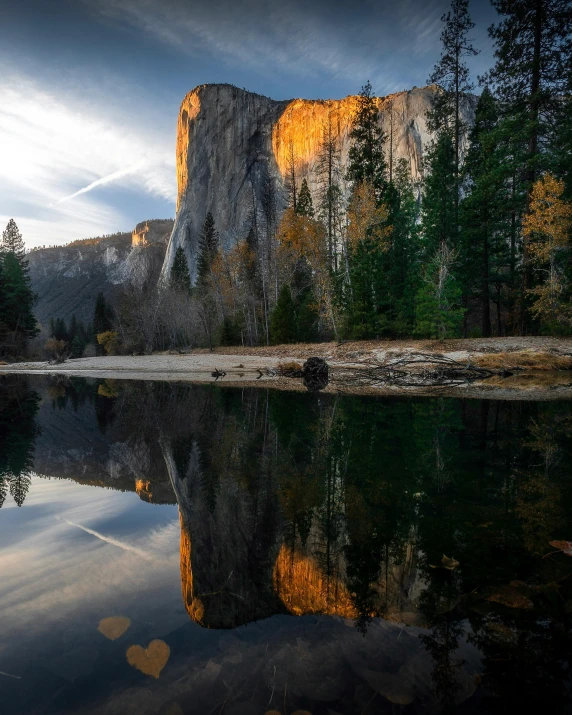 a body of water with a mountain in the background, el capitan, reflecting light, monolith, trees and cliffs