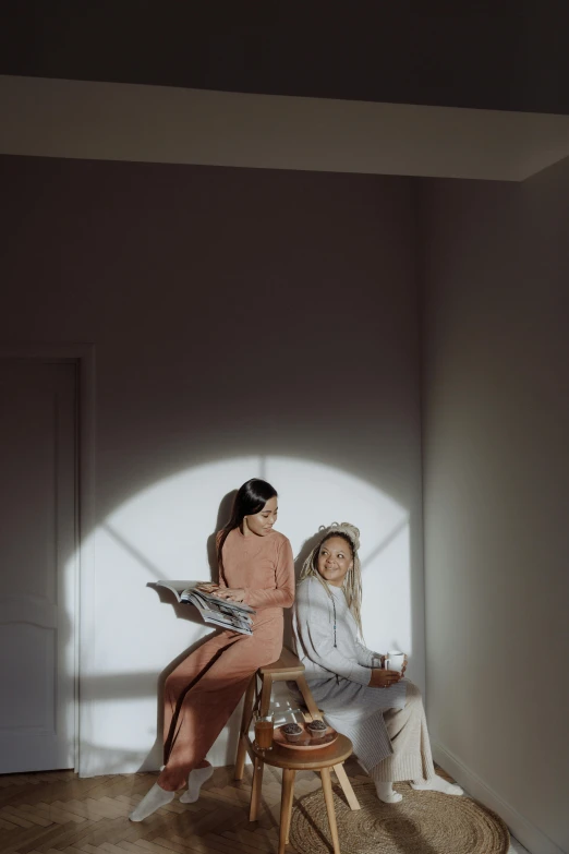 two women sitting on a stool in a room, by mads berg, trending on pexels, lumen global illumination, low quality photo, backlighted, concept photo