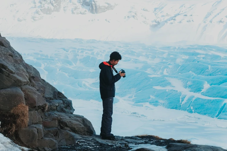 a man standing on top of a snow covered mountain, pexels contest winner, shooting ice, avatar image, full body profile camera shot, blue glacier