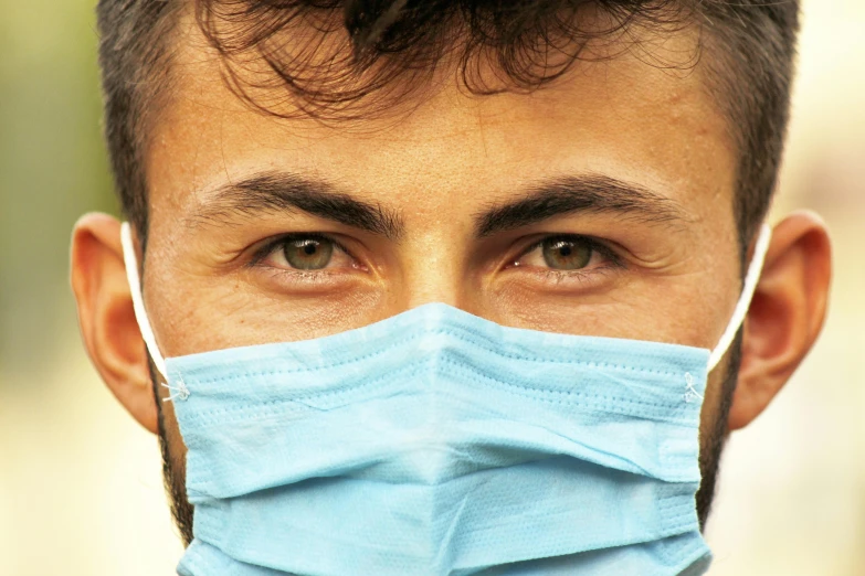 a close up of a person wearing a face mask, trending on pexels, hurufiyya, handsome eyes, wearing a hospital gown, avatar image, cover story