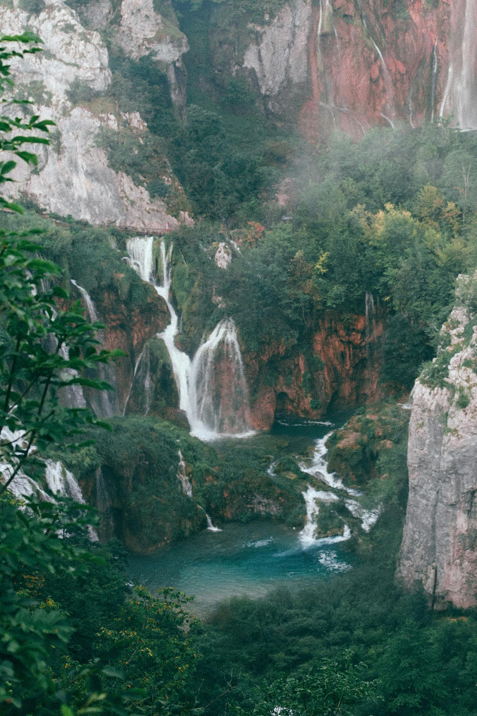 a waterfall in the middle of a lush green forest, unsplash contest winner, romanticism, terraced orchards and ponds, majestic spires, split near the left, water mists