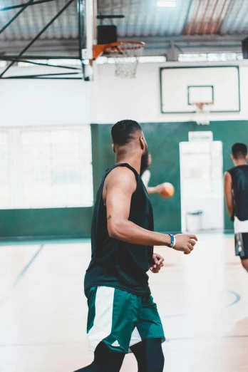 a group of young men playing a game of basketball, by Robbie Trevino, trending on dribble, in a gym, a green, looking across the shoulder, riyahd cassiem