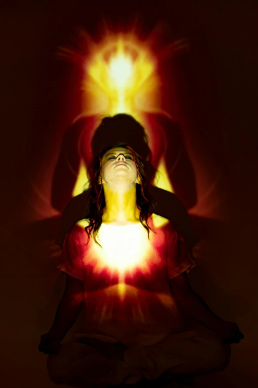a woman sitting in a lotus position with her eyes closed, inspired by David LaChapelle, light and space, red and yellow light, flaming heart, fresnel effect, in a sunbeam