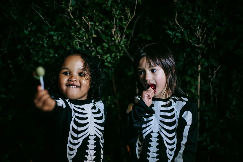 two little girls dressed up in skeleton costumes, by Lee Loughridge, pexels contest winner, outdoors at night, cute boys, bowater charlie and brom gerald, riyahd cassiem
