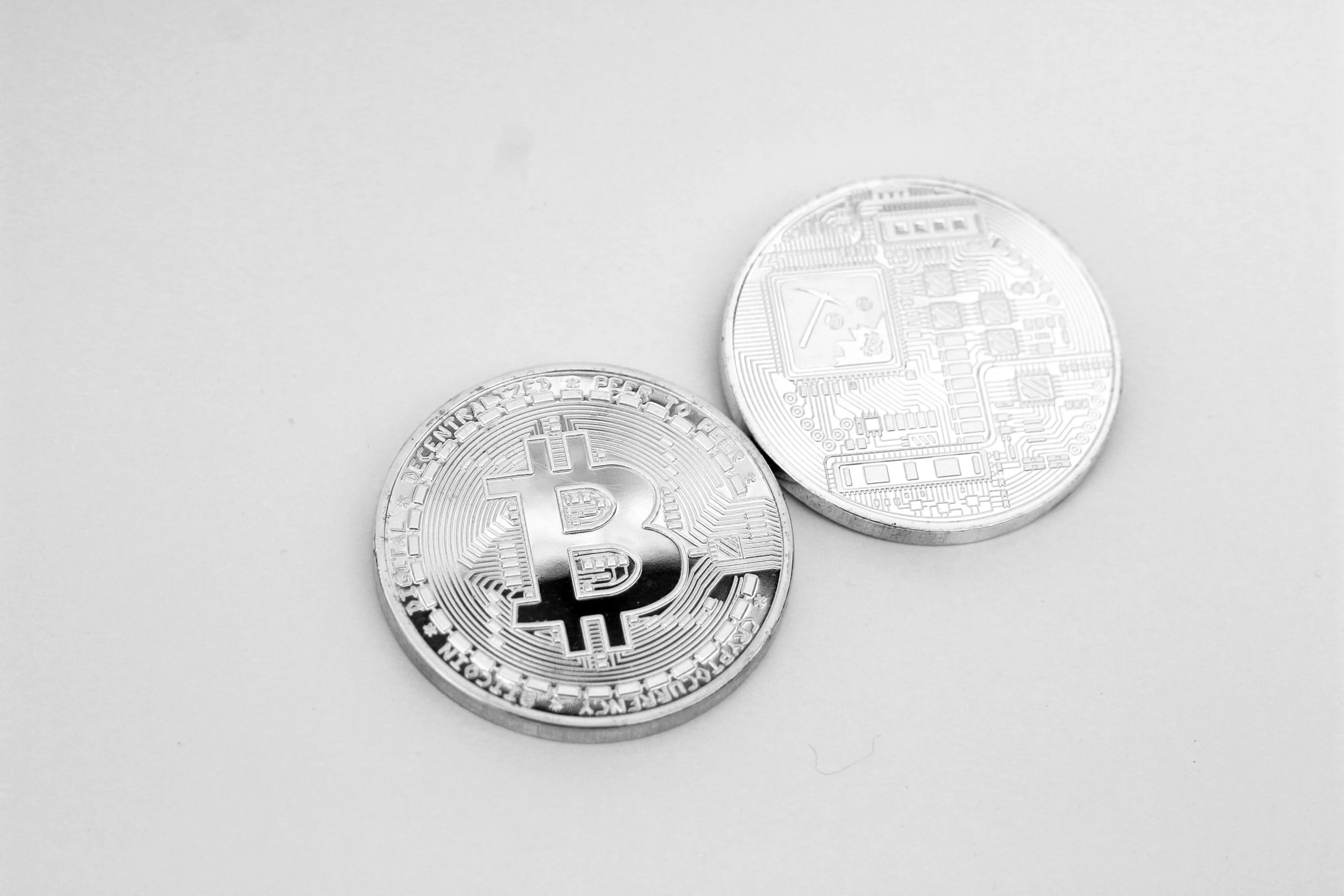 two bitcoins sitting next to each other on a white surface, a black and white photo, pixabay, silver ornaments, product introduction photos, 000 — википедия, monochrome 3 d model