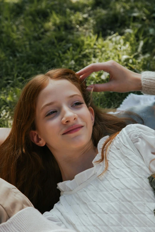 a woman laying on a blanket in the grass, inspired by Sophie Anderson, trending on pexels, red haired teen boy, mackenzie foy, official screenshot, portrait of white teenage girl