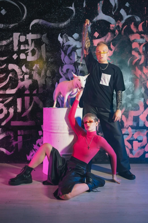 a group of people standing next to each other on a stage, an album cover, antipodeans, resembling a mix of grimes, with dogs, neon pink and black color scheme, portrait of two people