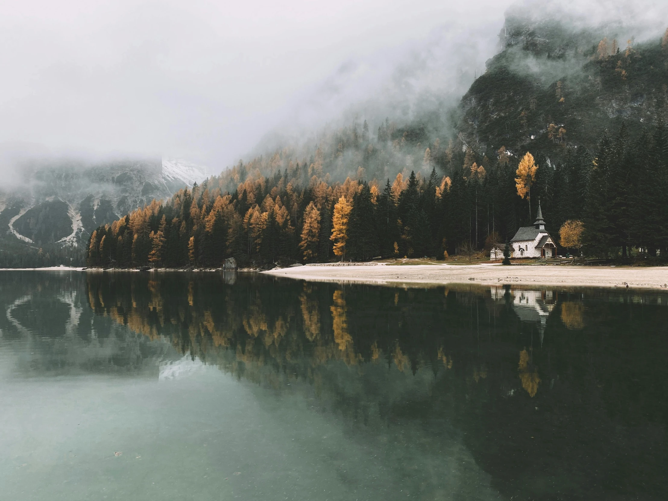 a boat sitting on top of a lake next to a forest, pexels contest winner, minimalism, hyperrealistic fall, dolomites, solitary cottage in the woods, under a gray foggy sky