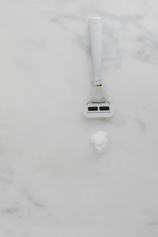 a razor sitting on top of a marble counter top, inspired by Robert Mapplethorpe, face made out of clouds, emily rajtkowski, white plastic, vibrating