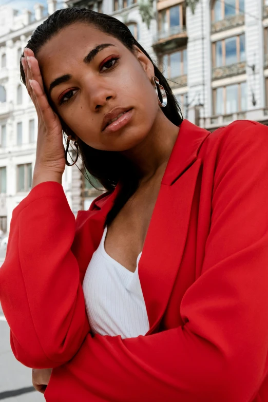 a woman in a red jacket posing for a picture, trending on pexels, renaissance, aida muluneh, sad look, light-brown skin, kano)