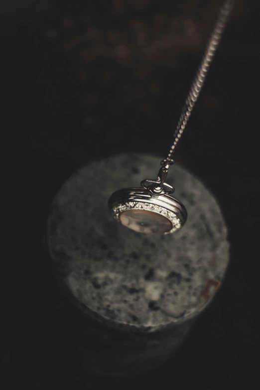 a silver necklace sitting on top of a rock, a macro photograph, unsplash, conceptual art, orrery, fine details portrait, silver，ivory, bespoke