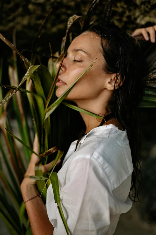 a woman standing next to a tree with her eyes closed, unsplash, renaissance, tropical style, skincare, profile image, made of bamboo