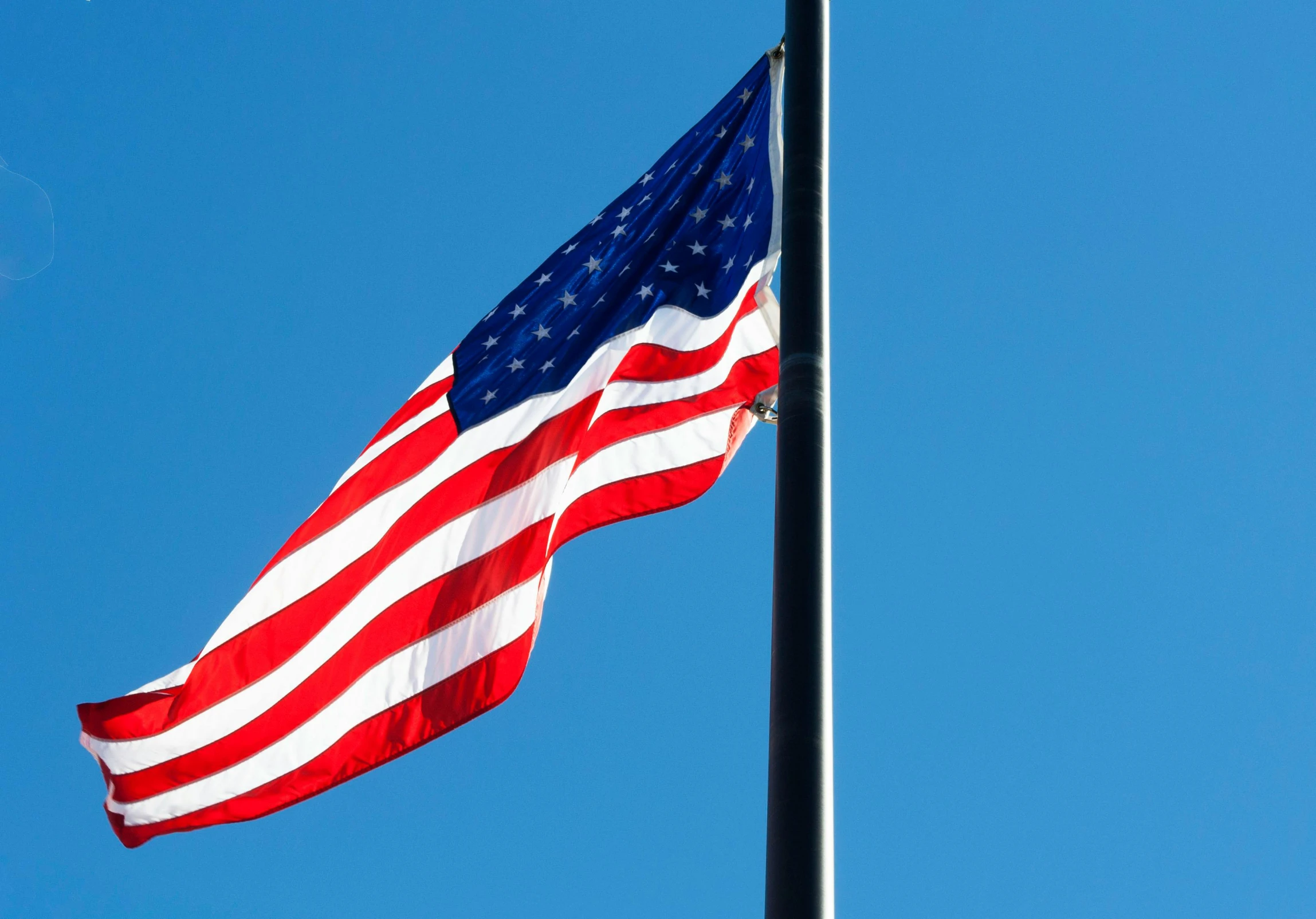 an american flag blowing in the wind against a blue sky, a portrait, unsplash, hurufiyya, slide show, various posed, profile image, cloudless sky